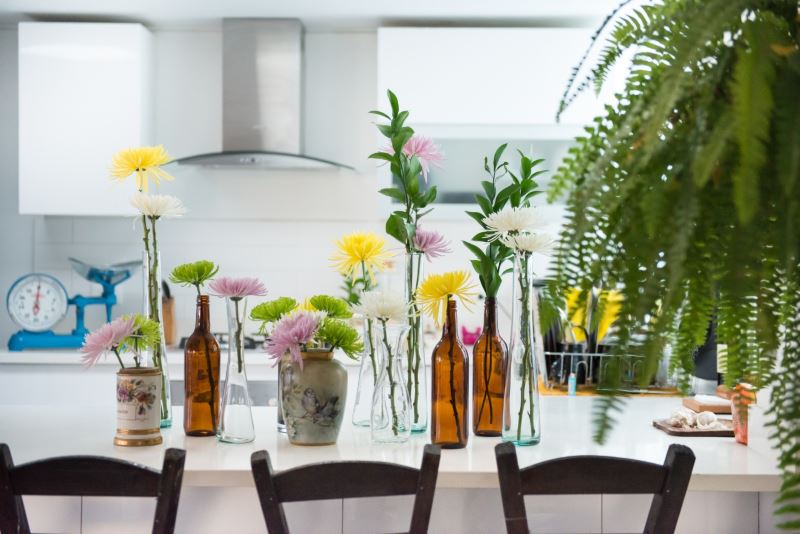 Freshly styled dining table with yellow flowers and ferns