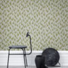 a chair and a vase in front of a wallpaper