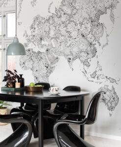 a table with a cup and chairs in front of a wall with a map of the world